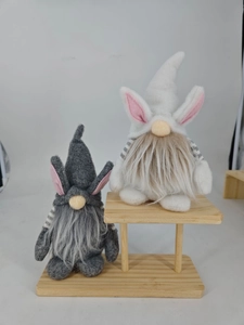 Close-up of gray and white Easter bunny gnomes with long faux fur on a wooden display stand