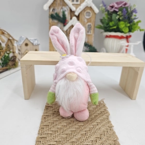Dettaglio dello gnomo di Pasqua rosa con orecchie da coniglio su tappeto rustico