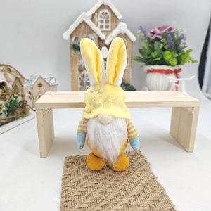 Dettaglio dello gnomo pasquale con orecchie di coniglio su sfondo di legno accogliente