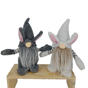 Easter gnome plush set with bunny ears and striped arms on a small wooden bench