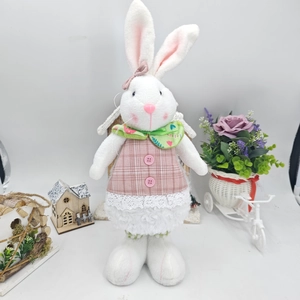 Detailed view of Easter rabbit doll in pink plaid dress with green bow tie decor