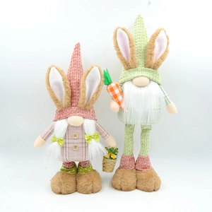 Dettaglio di gnomi pasquali rosa e verdi con carota e cesto di fiori decorativi