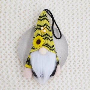 Detail of bee themed knitted gnome with sunflower decoration and long white beard