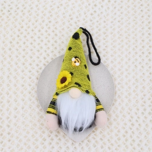 Macro detail of bee gnome plush with sunflower, hanging loop and striped knitted fabric