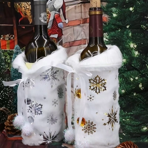 Close-up of plush Christmas wine bottle covers with gold and silver snowflake patterns