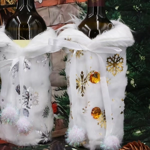 Close-up of white faux fur wine bottle covers with metallic snowflakes and ribbon bows