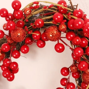 Couronne de Noël artificielle aux baies rouges pailletées sur base de brindilles brunes
