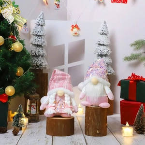 Pink Christmas faceless gnome figurines with sequins and glowing lights on wood