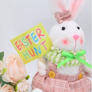 Easter plush bunny decoration wearing pink plaid skirt holding an Easter Hunt sign