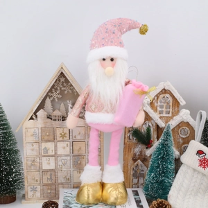 Nahaufnahme der rosa Weihnachts-Gnom-Puppe mit Pailletten und goldener Geschenktüte