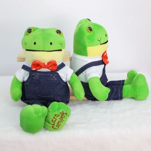 Long-legged frog plush toy wearing denim overalls and a red bow tie in a twin display