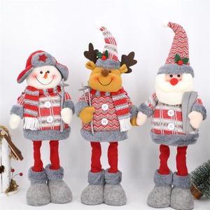 Détail macro de trois poupées de Noël en peluche avec motifs tricotés à carreaux