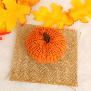 Detail of hand-knitted orange pumpkin decor with soft texture for harvest festival