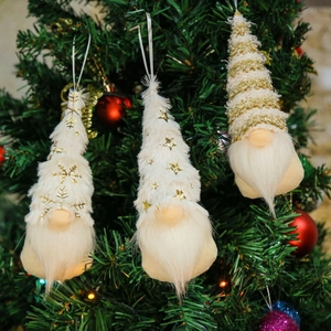 Detail of white and gold Christmas gnome ornaments with snowflake and star patterns