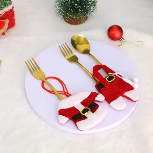 Christmas silverware holder set with Santa clothes and pants on a white festive plate