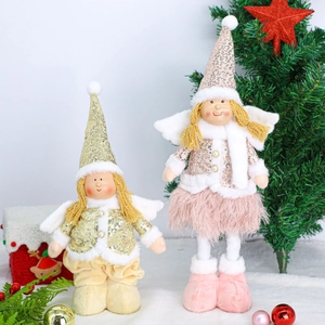 Detail view of plush Christmas angel dolls with sequins and wings on snowy decor
