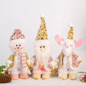 Detail of Christmas plush figurines with sequin hats and skis in pink and gold tones