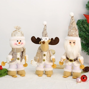 Close-up of Santa, snowman and elk plush dolls with ski gear on snowy background