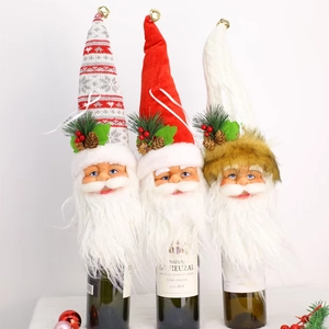 Three Santa wine bottle covers with white beards, pine cones, and bells for Christmas