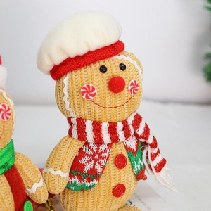 Detailed view of knitted gingerbread man with chef hat and red scarf for Christmas decoration
