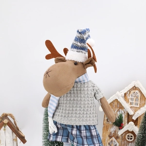 Detail der Weihnachts-Rentier-Plüschpuppe mit Waffelstrickpullover und gestreiftem Schal