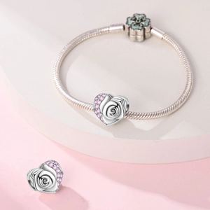 Silver snake chain bracelet with pink zircon heart rose charm and clover clasp detail