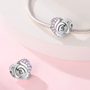 Macro view of heart-shaped silver rose charm with pink zircon stones for DIY bracelets