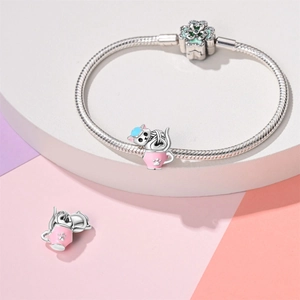 Detail van zilveren slangenarmband met een schattige emaille kat in een theekop