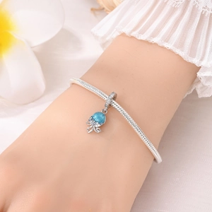 Détail du charm méduse en argent 925 avec pierres bleues sur bracelet à maille serpent