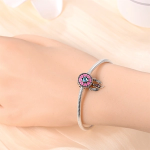 Detail of silver snake chain bracelet with pink and blue dreamcatcher charms and feathers