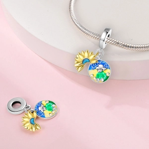 Detail of silver sunflower and artistic enamel charm on jewelry display stand