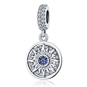 Detail van een zilveren schijfhanger met donkerblauwe kristal en pavé zonnestraal design