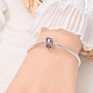 Zilveren slangenarmband met roze emaille rock kat hanger gedragen aan de pols