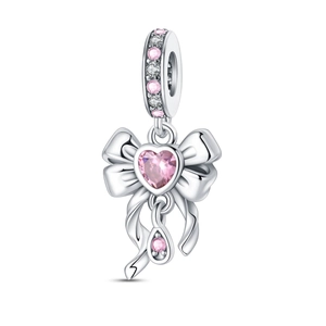 Close-up of bow charm with pink heart gemstone and sparkling stones on silver band