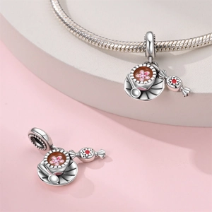 Makroaufnahme von versilbertem Kaffeetassen- und Süßigkeiten-Charm mit Emaille-Finish