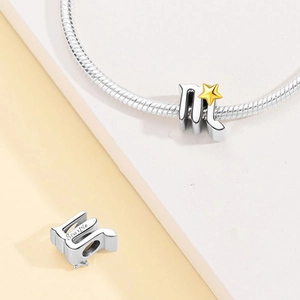 Detailed view of silver Scorpio zodiac charm with gold star and side engraving on snake chain