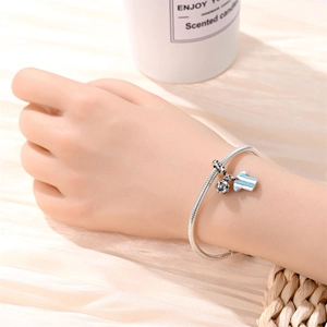 Detail of silver snake chain bracelet featuring soccer ball and striped jersey charms