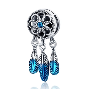 Macro detail of dreamcatcher charm with blue zircon and blue gradient enamel feathers