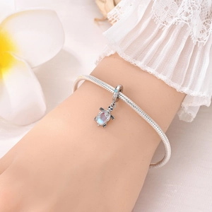 Détail du bracelet chaîne serpent en argent avec pendentif tortue de mer et pierres bleues