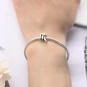 Detail of silver snake chain bracelet featuring a Virgo zodiac charm with a gold star