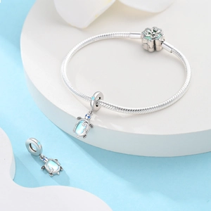 Vue détaillée de breloques tortue en argent 925 avec pierres bleues sur bracelet serpent