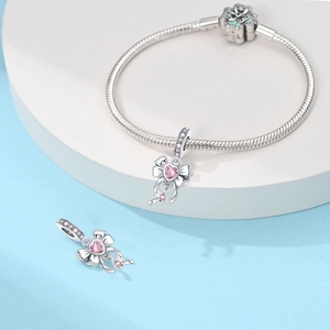 Detail of silver snake chain bracelet with pink heart gemstone and enamel floral clasp