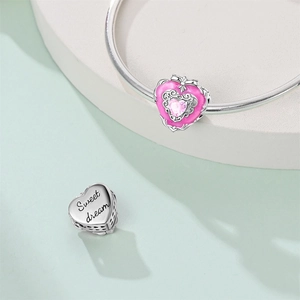 Close-up of pink enamel heart charm with Sweet Dream engraving and gemstone detail