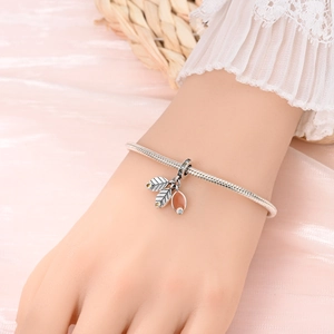 Details des Schlangenketten-Armbands mit herbstlichen Blattanhängern und orangefarbenem Tropfen