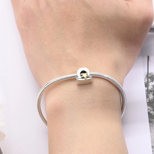 Detail of silver snake chain bracelet with Libra zodiac charm and golden star on wrist