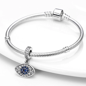 Detail van zilveren slangenarmband met boze oog hanger bezet met blauwe zirkonia's