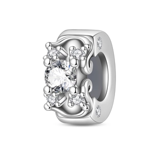 Macro shot of silver clover charm with sparkling main stone and vintage engravings