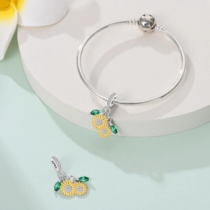 Detail of sunflower charm bracelet with We belong together engraving and yellow enamel petals