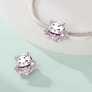 Détail de breloques chat argentées avec fleurs en émail coloré et zircons scintillants