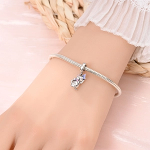 Bracelet maille serpent en argent avec pendentif chat émaillé rose porté au poignet